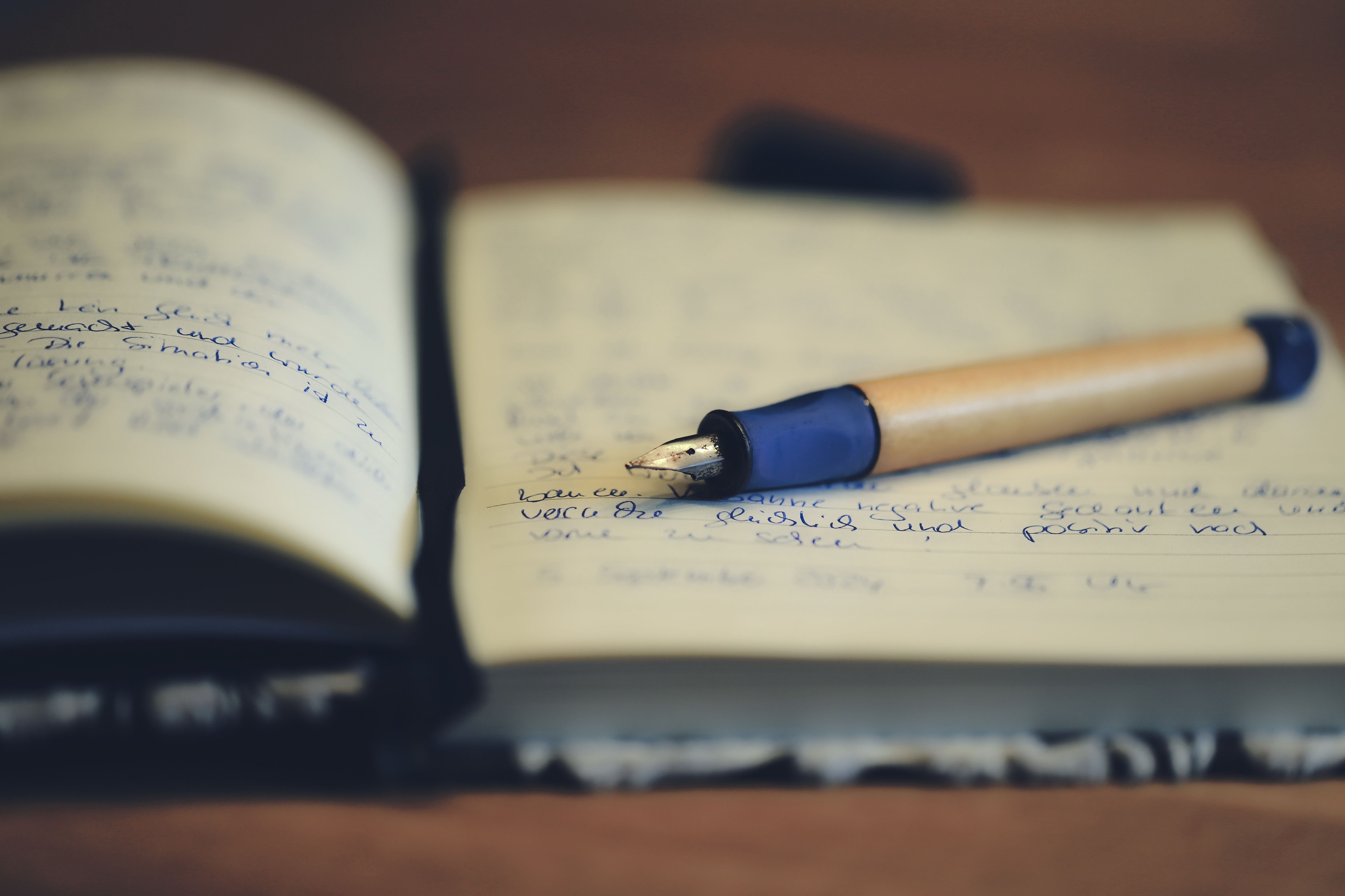 A close up of a fountain pen resting on an open notebook
